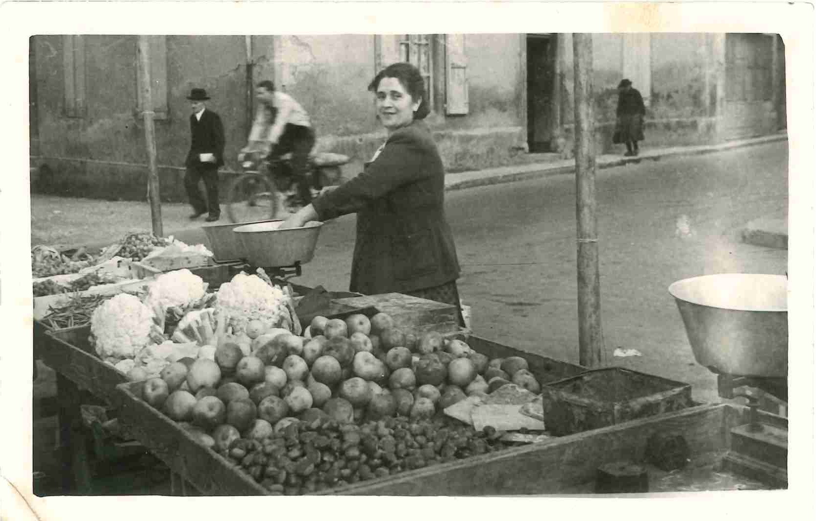 Marie Husni, épouse de Pascal, sur son étal du marché de la Place Prunelle à La Tour-du-Pin, 1947